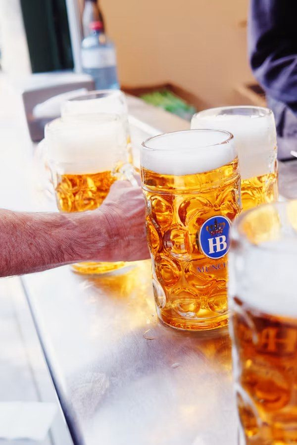 Những vại bia München trên bàn gỗ trong lều lễ hội